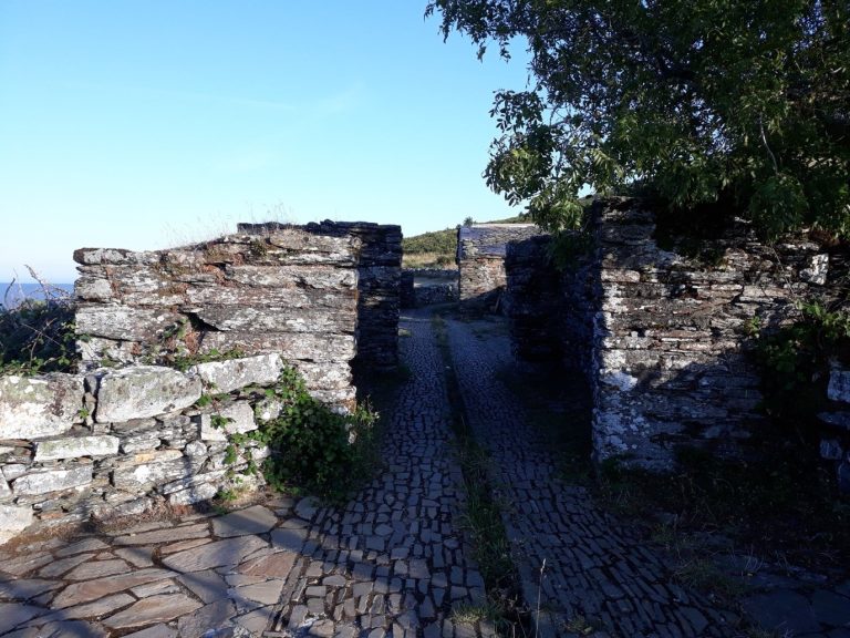 Stone ruins and a paved path at Montouto, on the Hospitales route, Asturias