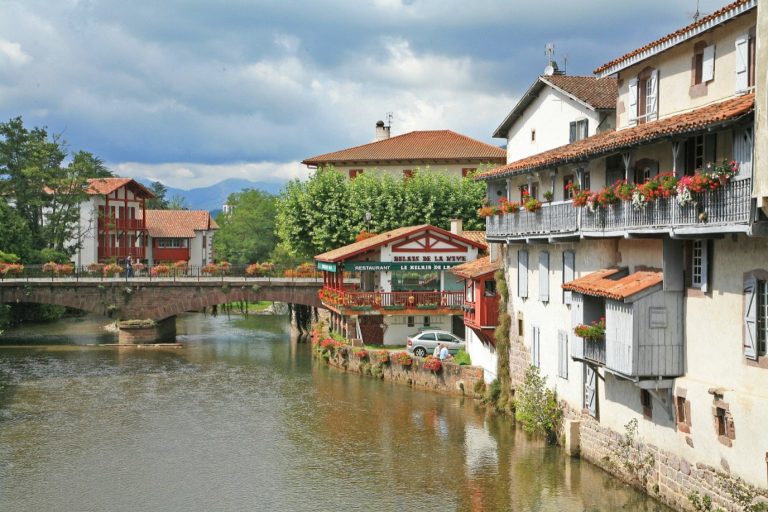 The river Nive and the houses with flower-decked balconies in Saint-Jean-Pied-de-Port